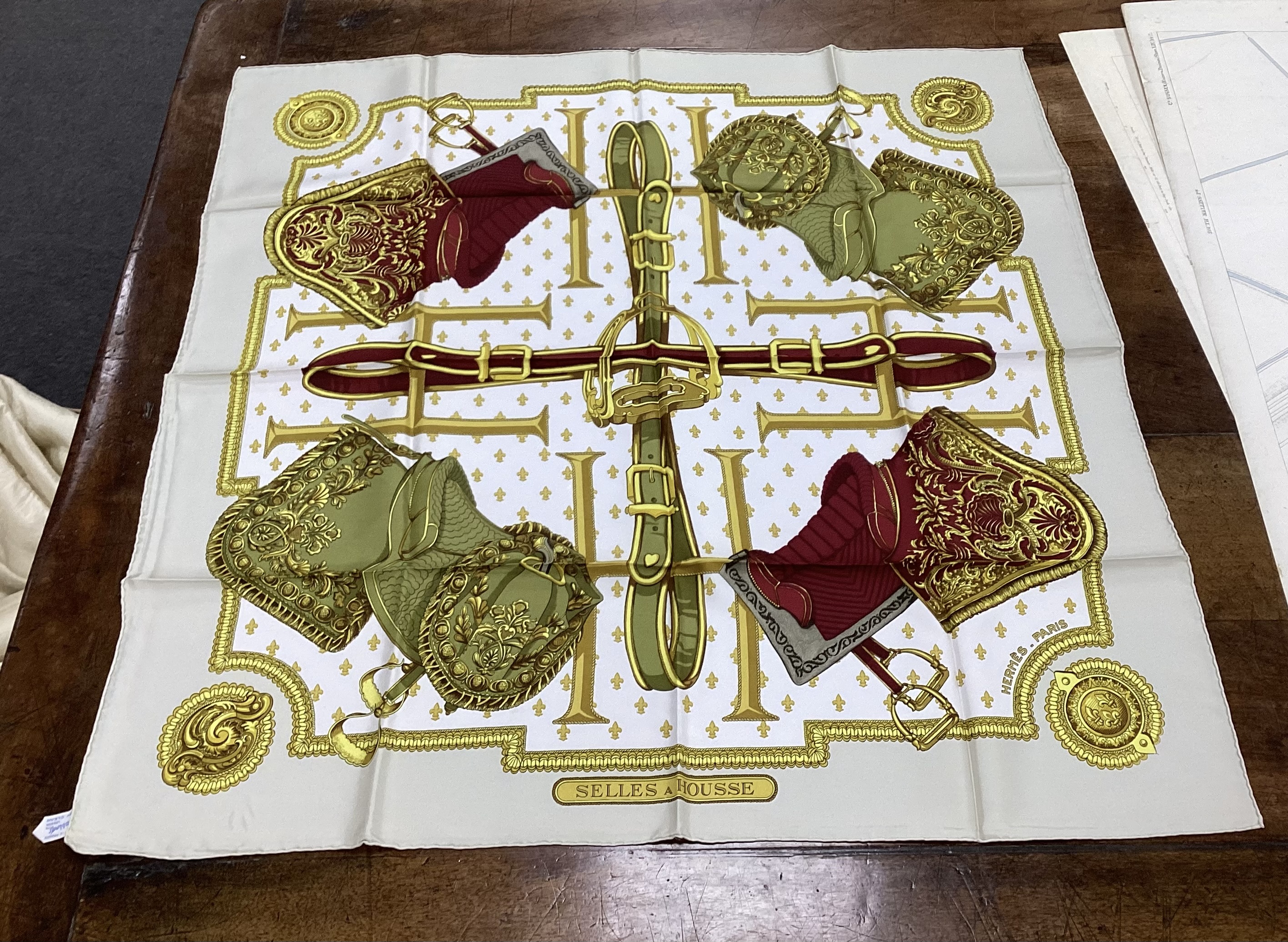 Four vintage Hermes silk scarves including one retailed by Harrods comprising, Selles A Housse, Roues de Canon, Passementerie and a rectangular Brides de Gala example